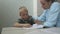 Portrait school kid siting on table doing homework, home schooling