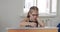 Portrait school kid siting on table doing homework, school and home schooling,