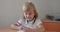 Portrait school kid siting on table doing homework, school and home schooling, Distance education.