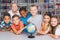 Portrait of school kids looking at globe in library