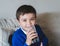 Portrait schoolboy drinking soda or soft drink with glass,Child enjoying cold fizzy dink after back from school,Kid relaxing at