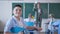 Portrait of schoolboy in elementary school, teacher explains lesson to children with cards near blackboard in class