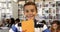 Portrait of schoolboy holding books in library