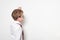 Portrait of a schoolboy in round glasses. Pretends to write on the chalkboard. White background