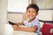 Portrait of schoolboy using digital tablet in classroom