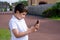 Portrait schoolboy using smartphone typing text messages, Happy kid standing outdoor using cellphone chatting with friends,Child