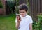 Portrait schoolboy using smartphone typing text messages,Happy kid standing outdoor using cellphone chatting with friends,Child