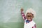 Portrait of schoolboy wearing wig doing mathematics on chalkboard in classroom