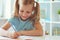 Portrait of schoolgirl at classroom writing at the table