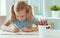 Portrait of schoolgirl at classroom writing at the table