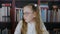 Portrait schoolgirl in round spectacles with two hair tail on bookshelf background. School girl in glasses on bookcase