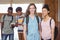 Portrait of schoolgirls standing with classmate with classmates in background