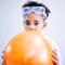 Portrait, science and a kid blowing a balloon in studio on a gray background for a childhood experiment. Children