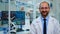 Portrait of scientist man smiling at camera sitting in modern laboratory