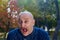 Portrait of a screaming bald man in a blue sweater