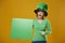 Portrait of screaming leprechaun pointing at banner with copy space