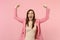 Portrait of screaming young woman rising arms, expressive gesticulating with hands isolated on pastel pink wall