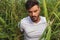 Portrait of seated casual man in a green grass field