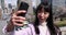 A portrait of selfie by Japanese woman behind cherry blossom