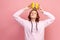 Portrait of selfish curly haired teenage girl in hoodie holding gold crown over head, looking with arrogance, privileged status