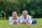 Portrait of senior Asian couple lying down on the grass in the public park looking at the camera with good mental health for