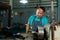 Portrait of a senior Asian man who is a blacksmith. Inspecting small steel turning tools. to prepare the lathe In the family`s