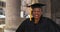 Portrait of senior black woman in graduation gown, smiling and cheering