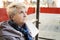 Portrait of senior blonde woman sitting on bus stop