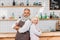 portrait of senior coffee shop owners with arms crossed standing at counter