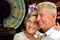 Portrait of senior couple posing on blurred casino background