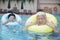 Portrait of senior couple relaxing in the pool with inflatable tubes