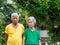 Portrait of senior couple wears colorful cloth and looking at camera while standing in a garden