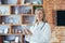 Portrait of a senior experienced doctor with a tablet in the office looking at the camera and smiling