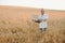 Portrait of senior farmer agronomist in wheat field checking crops before harvest. Successful organic food production and