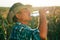 Portrait of a senior farmer drink water. in the cornfield,