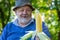 Portrait of senior farmer giving ripe ear of maize shallow dof