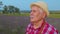 Portrait of senior farmer worker grandfather man in organic field growing purple lavender flowers