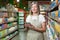 Portrait of senior female consultant, employee in grocery store, supermarket. Stands with a tablet, accepts the goods, checks. In