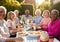 Portrait Of Senior Friends Enjoying Outdoor Dinner Party At Home