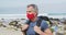 Portrait of senior hiker man wearing face mask with backpack hiking on the beach.