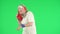 Portrait of senior hipster on Chroma key green screen, cool old man in headphones with speaker jamming to music