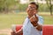 Portrait of a Senior Indian retired male sitting on the red bench in a park and showing his inked finger after casting their vote