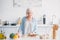 portrait of senior lady cutting vegetables while cooking dinner at counter