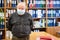 Portrait of senior male archivist with hands behind back looking at camera, man wearing facial mask due coronavirus pandemic,