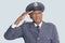 Portrait of a senior male US Air Force officer saluting over light blue background