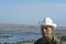 Portrait of senior man in hat. An elderly man stands on mountain, below there is a river and beautiful landscape. Seniors