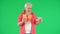 Portrait of senior man hipster on Chroma key green screen background, man holding paper cup and tablet talking by video