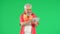 Portrait of senior man hipster on Chroma key green screen background, man holding tablet watching video smiling