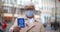 Portrait of senior man in safety mask looking at camera and holding vaccine passport outdoors