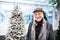 Portrait of senior man in shopping center at Christmas time, chain of light around head.